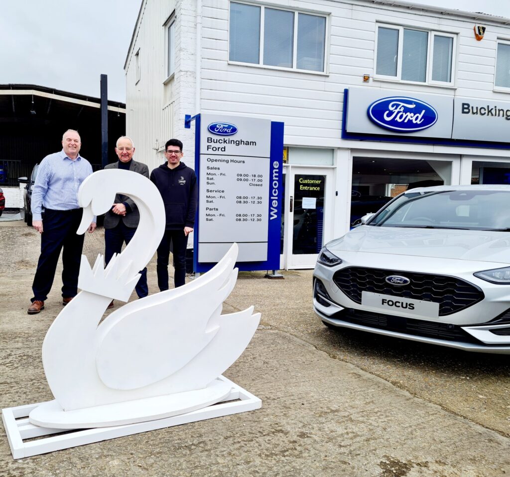 photo of a swan sculpture outside a car dealership shop