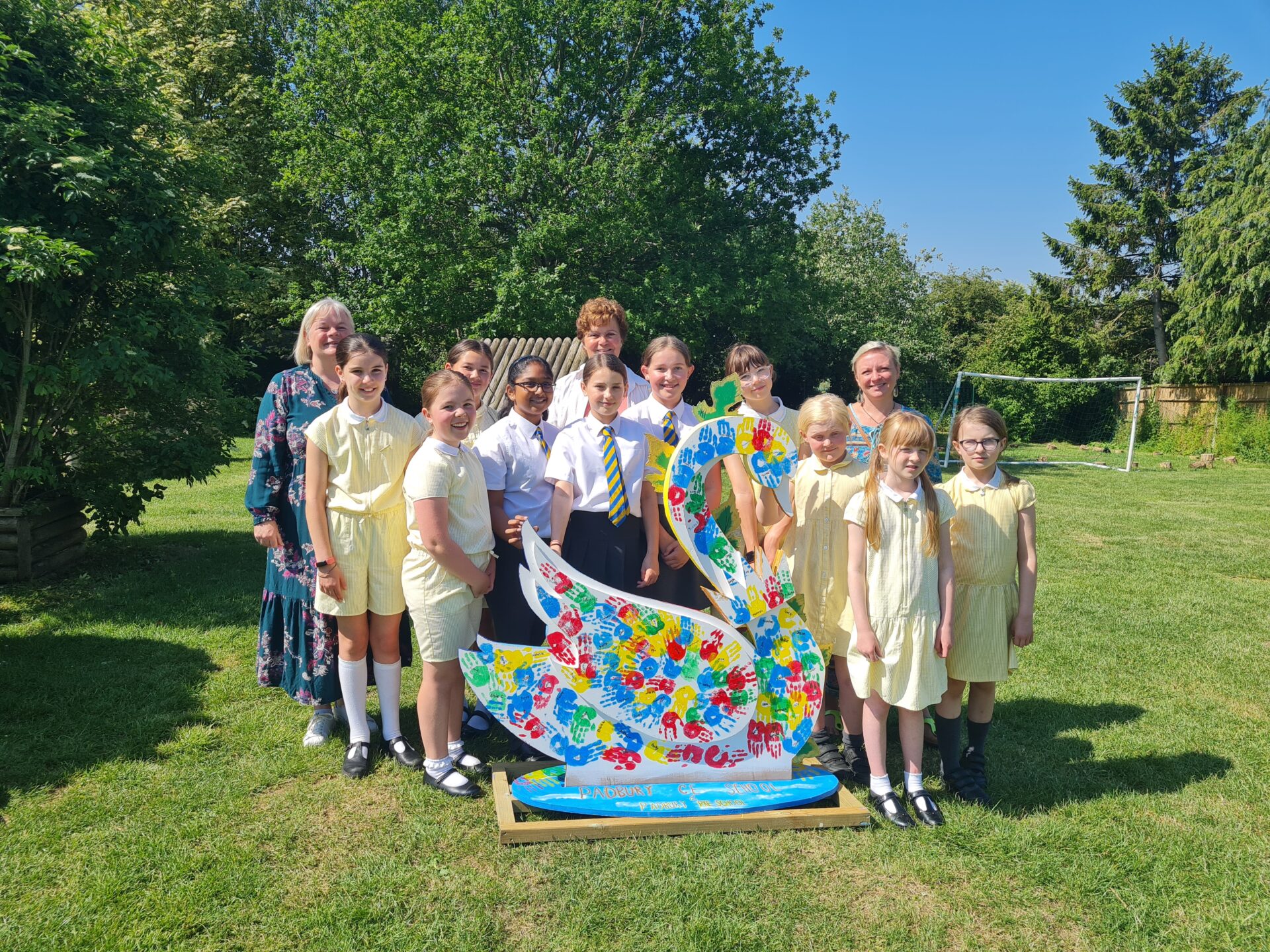 image shows a painted swan sculpture and school children
