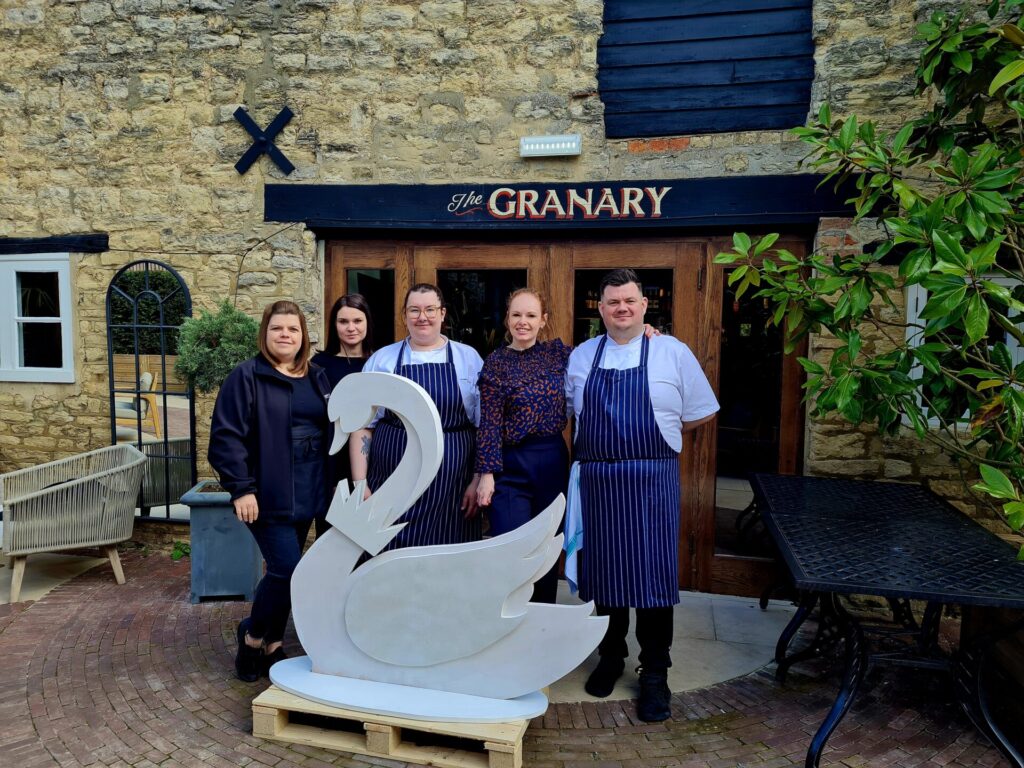 image shows a blank swan sculpture and staff on duty outside their place of work