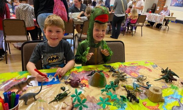 Two children play with dinosaurs
