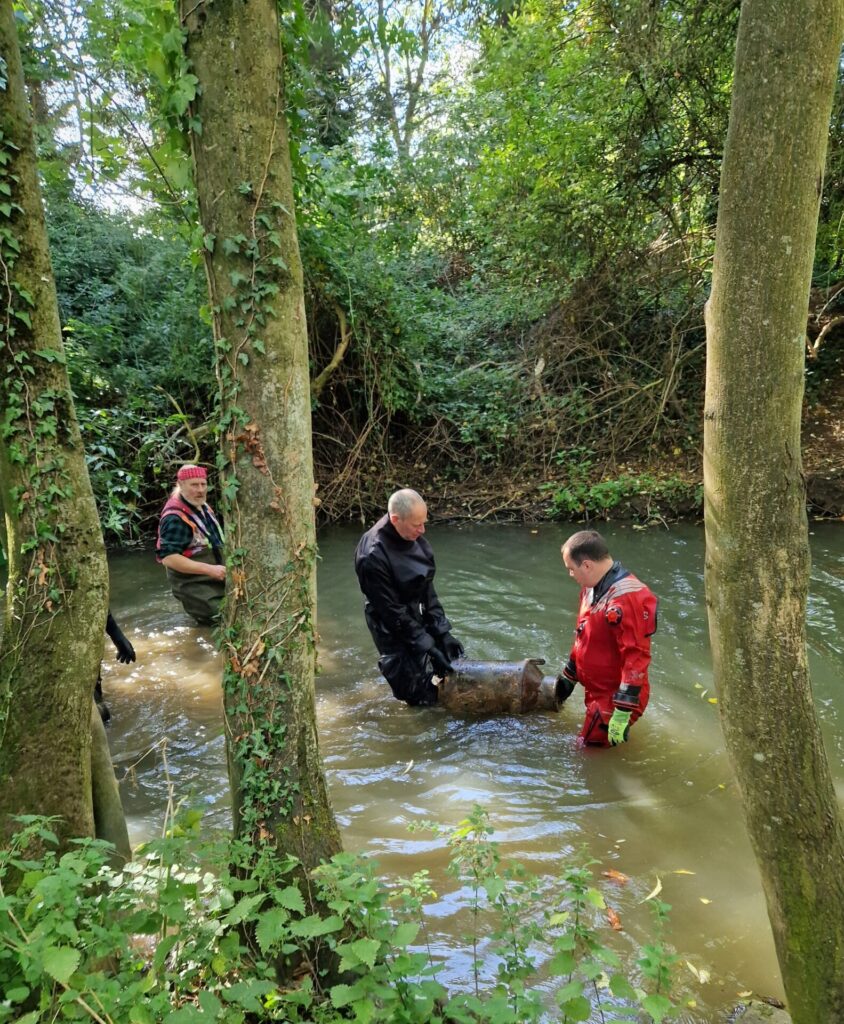 Divers in river removing debris
